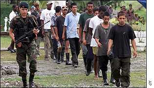 Colombian soldier (l) escorts AUC suspects 