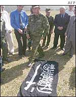 Russian officials looks at a flag seized from Chechen rebels 