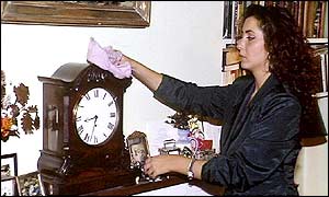 A woman dusting a clock