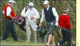 Furyk has to roll up his trousers as he plays out of the water at the seventh