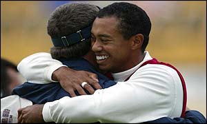 Davis Love III is congratulated by Tiger Woods after the pair win their second point of the day in the fourballs