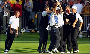 Europes Paul McGinley, third right, is mobbed by team-mates, Niclas Fasth, right, Darren Clarke, second right, Sergio Garcia, left, and caddies 