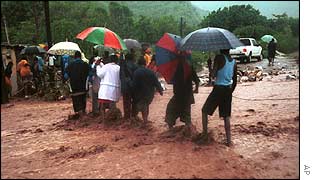 Residents of Bull Bay, Jamaica, struggle to cross a flooded street