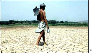 An Indian farmer walks across a parched, drought-hit field 
