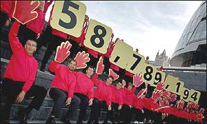 Volunteers display the UK's population figure