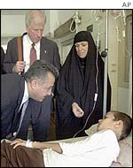 Mike Thompson talks to a patient in a hospital through an interpreter