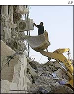 A man retrieves an air conditioner from Mr Arafat's ruined offices