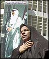 Iraqi woman in front of a poster of Saddam in Baghdad