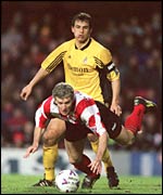 Mark Hughes in Southampton colours tumbles under a challenge from Chris Coleman of Fulham
