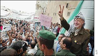 Yasser Arafat greets crowds outside his wrecked headquarters in Ramallah