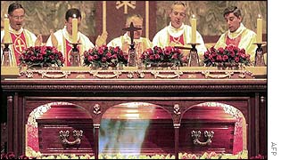 Priests praying over coffin
