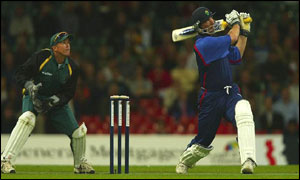 Matthew Maynard cracks a shot to the boundary while Andy Flower looks on