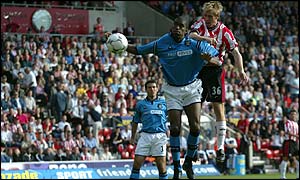 Brett Ormerod rises above Sylvain Distin to score his first goal against Manchester City