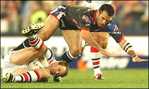 Luke Phillips of the Roosters is tackled by the Warriors' Stacey Jones 