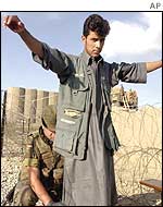 A German soldier searches a worker at a checkpoint
