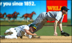 Oakland's Scott Hatterburg slides in, watched by Minnesota second baseman Denny Hocking