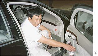 Chinese businessman Yang Bin gets into his car after a dinner at his Holland Village development in Shenyang, China, Monday Sept. 30, 2002. 