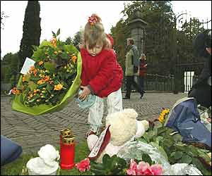 A little girl lays flowers for Prince Claus