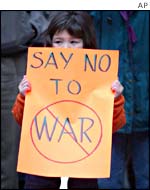 A girl holds an anti-war sign
