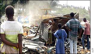 Foreign residents watch as their homes are bulldozed