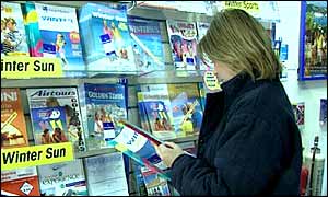 A woman in a travel agent looking at brochures