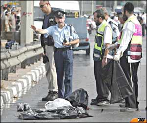 Policewoman and volunteers stand near the remains of the suicide bomber