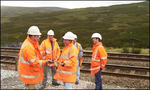 The centre of Scotland is on the hillside 250 metres behind these workers
