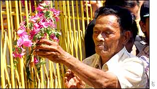 A Balinese man offers flowers near the bomb site, Kuta, Bali, Indonesia