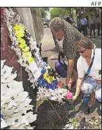 Tourists lay bouquets of flowers at the blast site in Legian street in the tourist area in Kuta