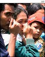 Onlookers outside Bali hospital hold their noses due to the smell 