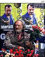 Rose-seller beside poster urging people to vote