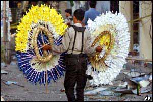 A police officer carries wreaths to the area of the ruined nightclub