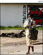 Bouake resident walks past corpse of government soldier