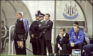 Danny Wilson (centre) is flanked by policeman as Wednesday plunge to an 8-0 defeat at Newcastle