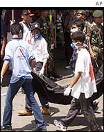 Rescue workers carrying a body bag from the bomb site