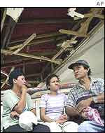 Passengers sit outside a damaged bus station in Kidapawan, southern Philippines