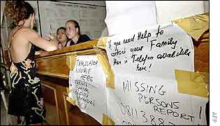 A woman (L) talks to hospital staff manning an information counter in Sanglah, Denpasar, Bali