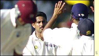 Anil Kumble receives a high-five from his team-mates after taking another wicket