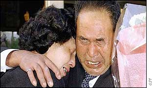 Hitomi Soga (left) cries as she is hugged by her father Shigeru, on her arrival at her former home in Mano, northern Japan, 17 October 2002