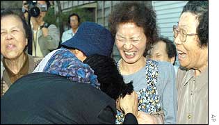 Kaoru Hasuike (foreground left) is embraced by his relatives 