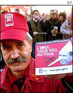 A striking worker carries a poster depicting Italian Premier Silvio Berlusconi as Pinocchio and reading 