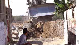 Palestinian boy throws stones at Israeli bulldozer in Rafah refugee camp