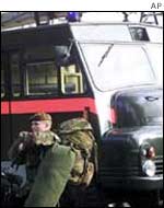 Soldier walks past a Green Goddess vehicle
