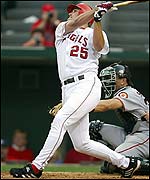 Anaheim Angels' Troy Glaus hits a homer as San Francisco catcher Benito Santiago watches