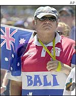 Man wearing a Bali shirt and carrying the Australian flag