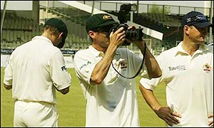 The Australian team take photos of the Sharjah celebrations as they contemplate heading home to face England in the Ashes