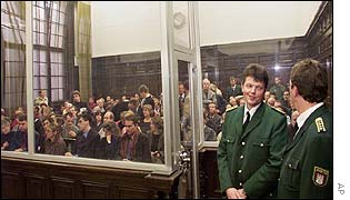 Journalists crammed in the court behind a bulletproof screen