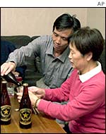 Kaoru Hasuike pours beer for his mother, Hatsui, during sushi dinner upon returning home, Kashiwazaki, central Japan