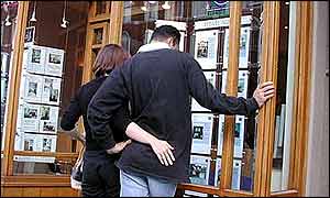 People looking in an estate agent's window