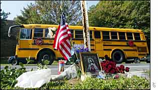 A school bus passes a memorial